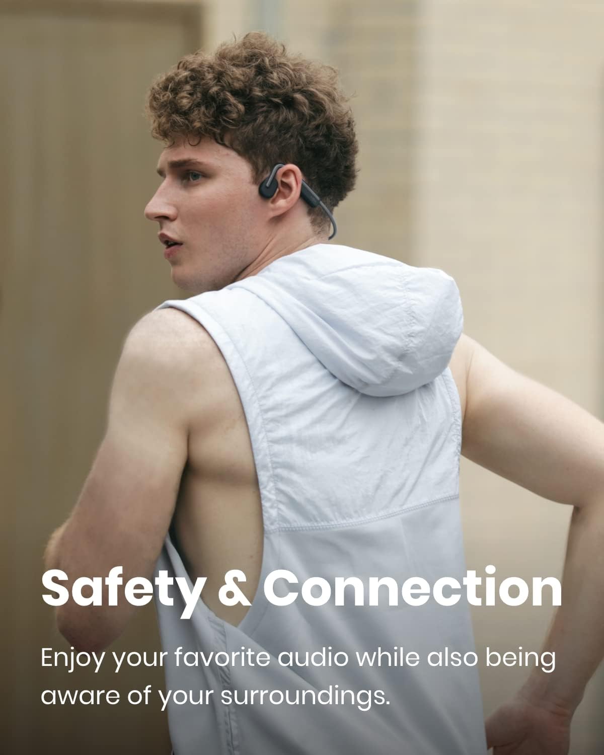A runner wearing the Shokz OpenMove open-ear headphones on a city run