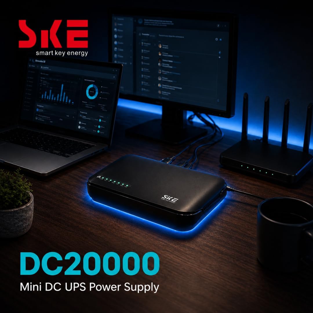SKE DC20000 mini DC UPS on a desk between a laptop and a WiFi router, its status LEDs glowing